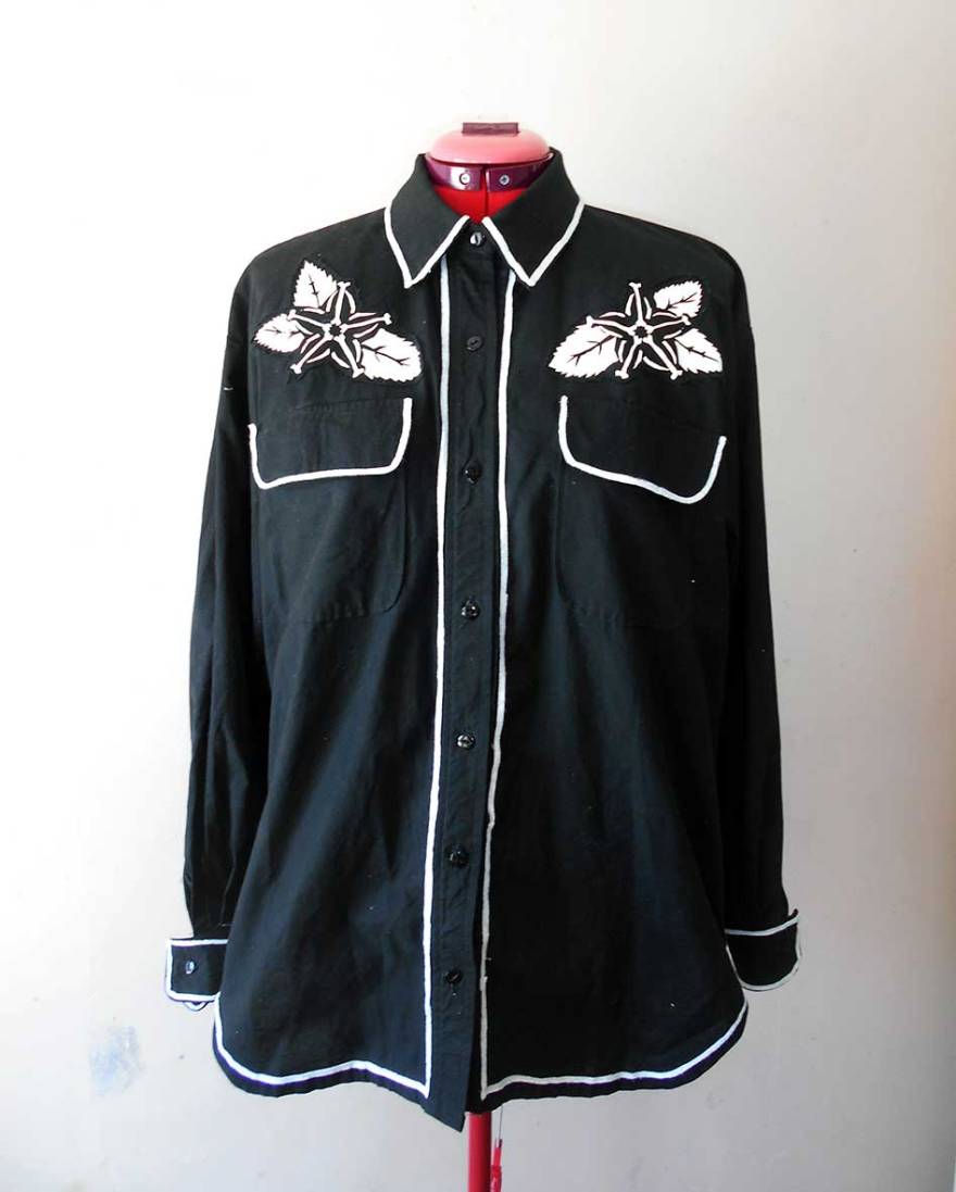 A black cowboy shirt with white piping and decorative motifs screen printed in white ink